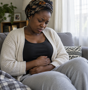 Woman holding her stomach while experiencing abdominal pain
